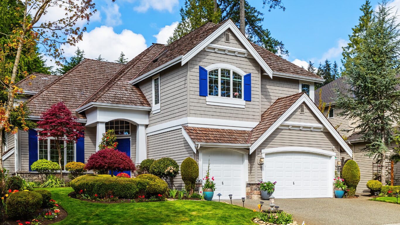 Refined two-story home with blue shutters and a manicured front yard